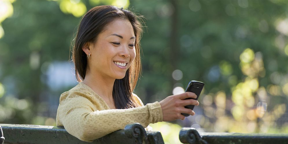 Ilustrasi perempuan tersenyum melihat handphone