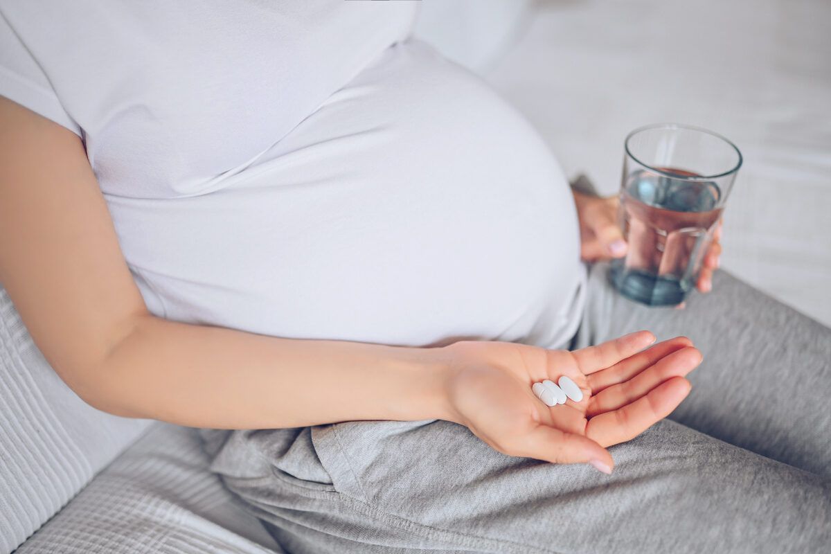 Ilustrasi ibu hamil minum vitamin