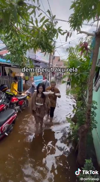 Wanita ambil makanan pernikahan di tengah banjir