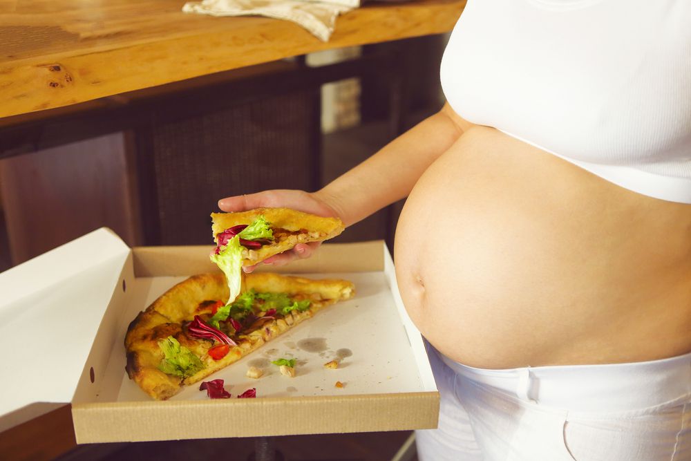 Ilustrasi ibu hamil makan pizza