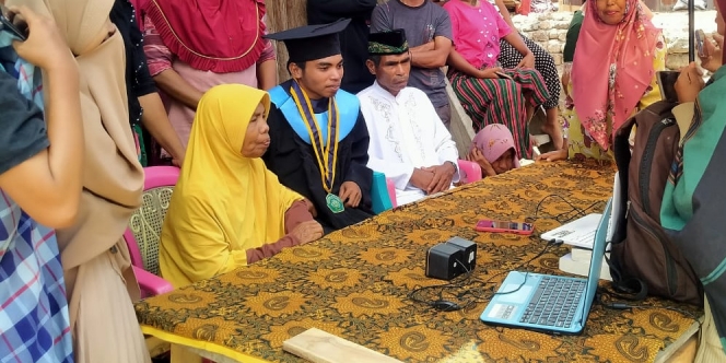 Momen Mengharukan Seorang Mahasiswa, Wisuda Online Ditemani Keluarga Besarnya di Kampung