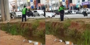 Sepi Orderan, Bapak Ojol Ini Sampai Bersihkan Kubangan Air Pinggir Jalan