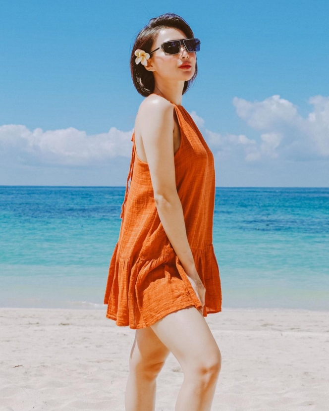 Makin Terlihat Manis dengan Bunga di Telinga, Ini Deretan Potret Wika Salim Liburan di Pantai dengan Sundress Orange